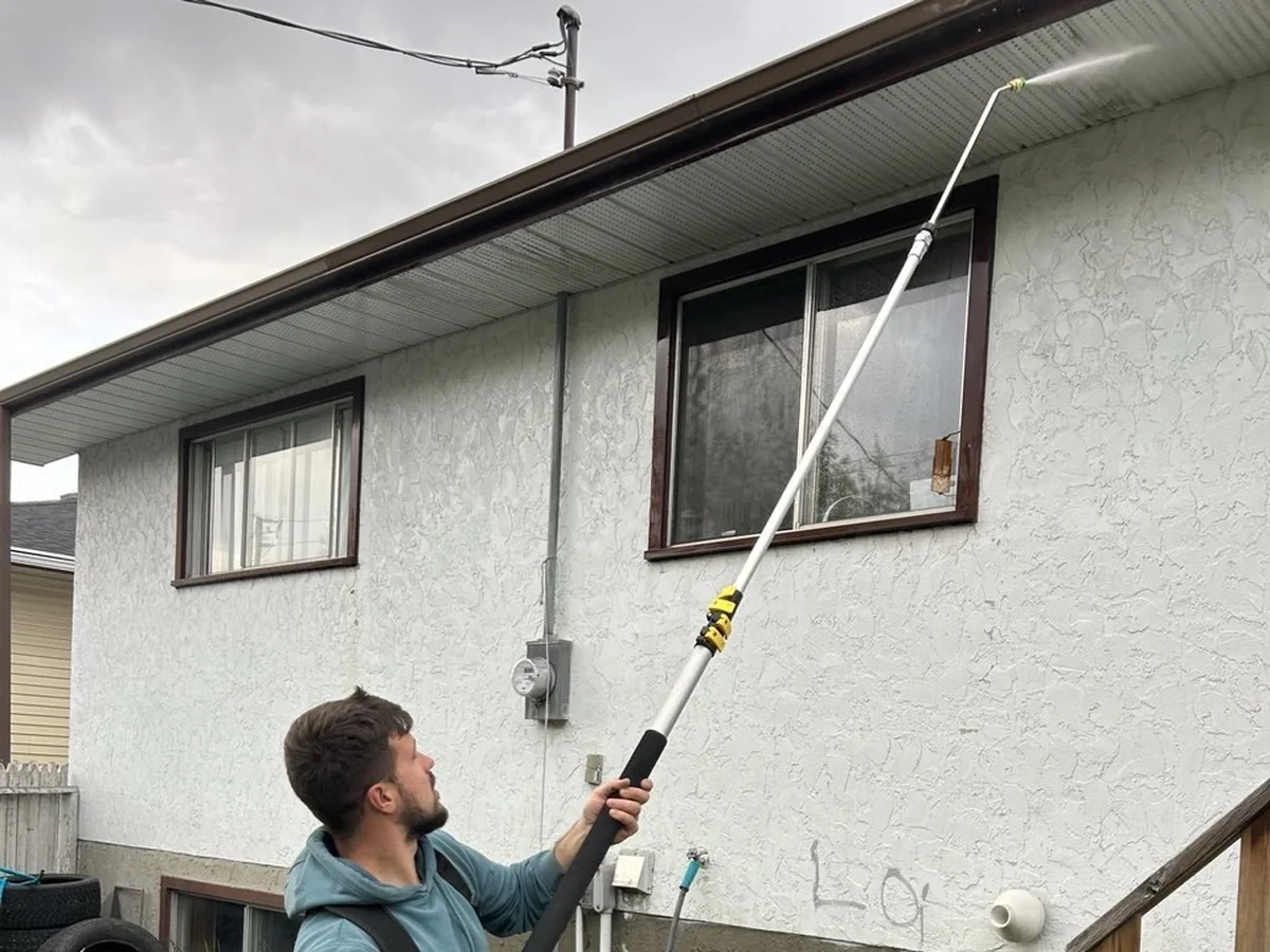 Pressure washing house siding with extension wand