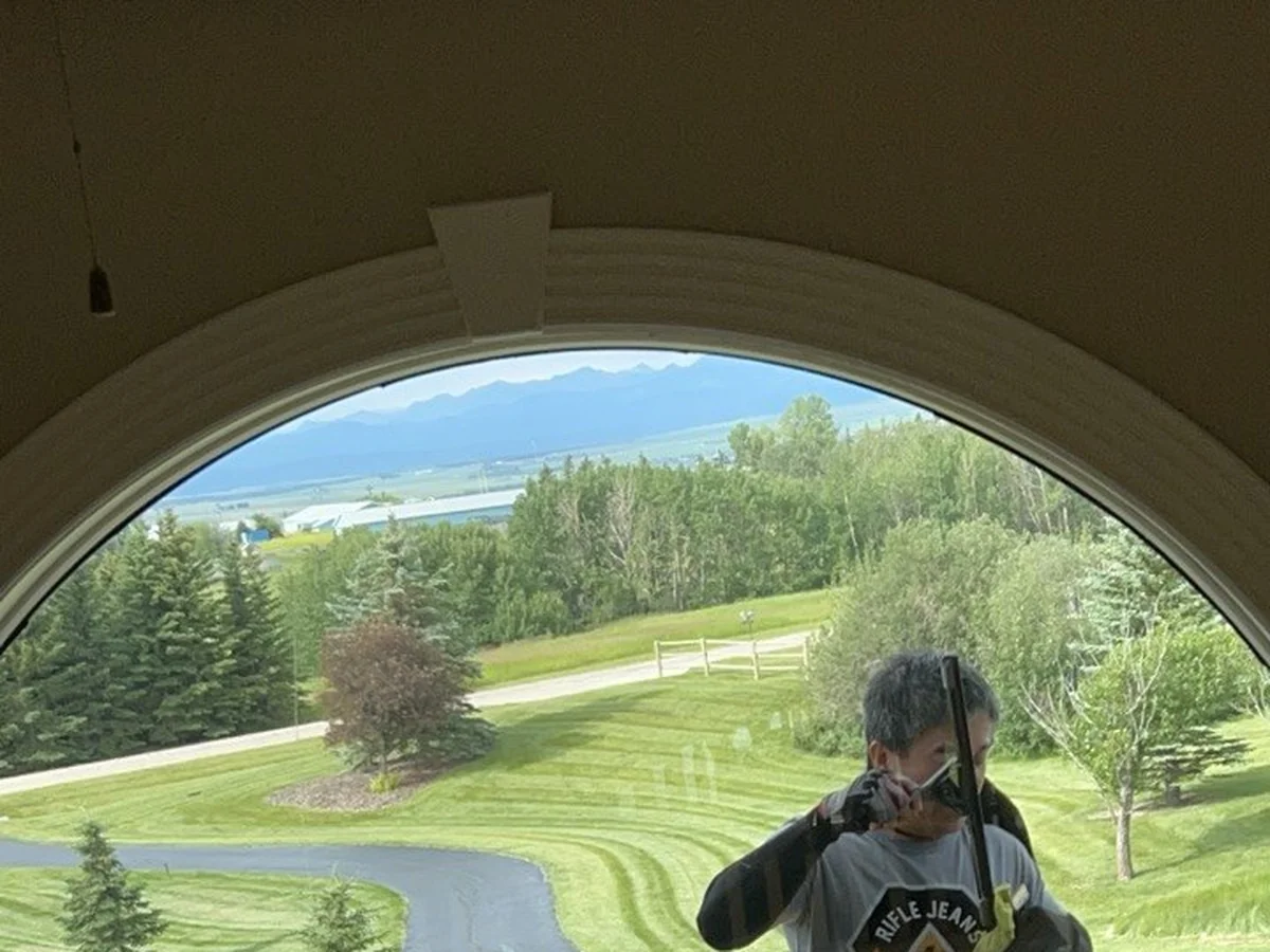 Window cleaning in custom home with mountain view